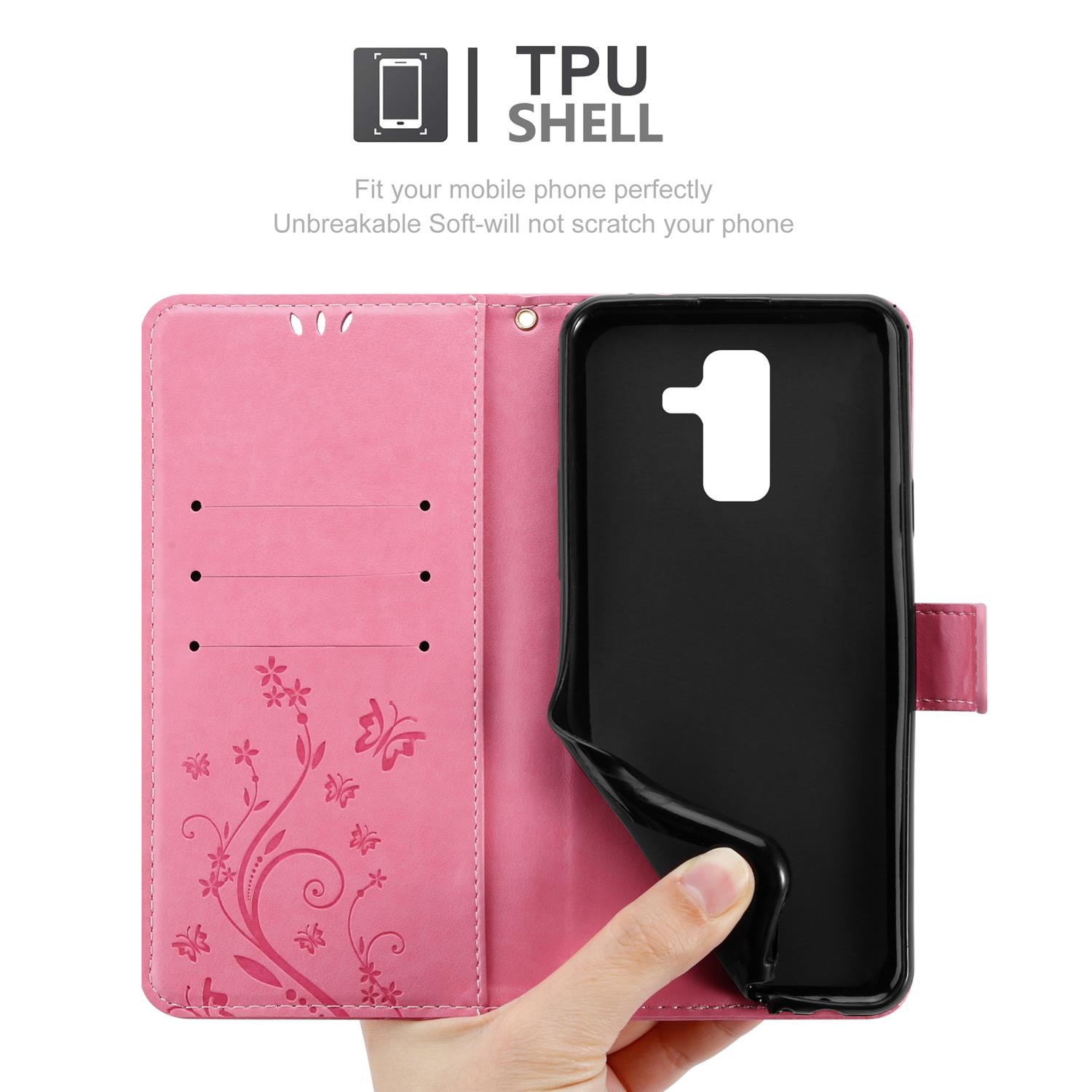 Una custodia per telefono rosa con un telefono nero all'interno. La cover ha un motivo floreale e dettagli a farfalla.