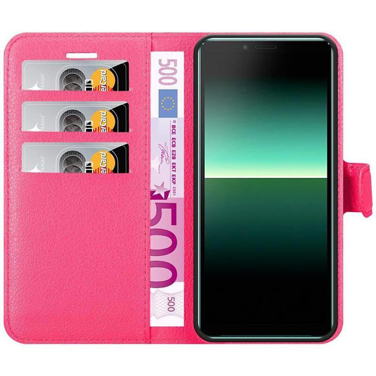 Custodia rosa con telefono, slot per carte e banconote in euro. Il telefono è dentro.