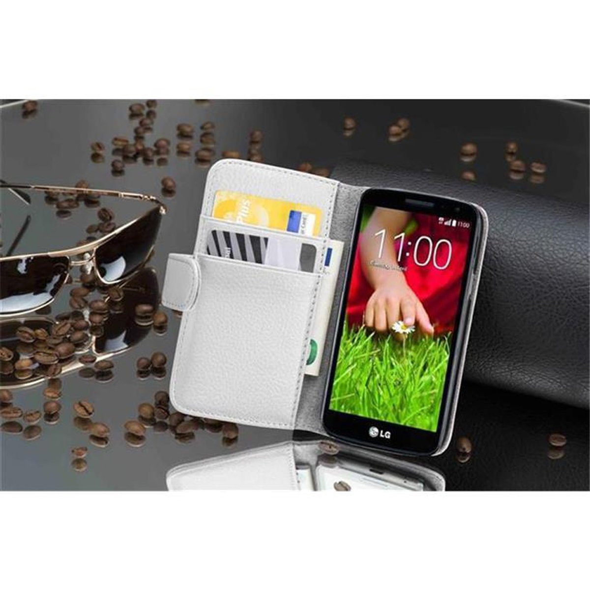 Custodia a portafoglio bianca con telefono, carte di credito e denaro, su una superficie riflettente. Occhiali da sole e chicchi di caffè presenti.