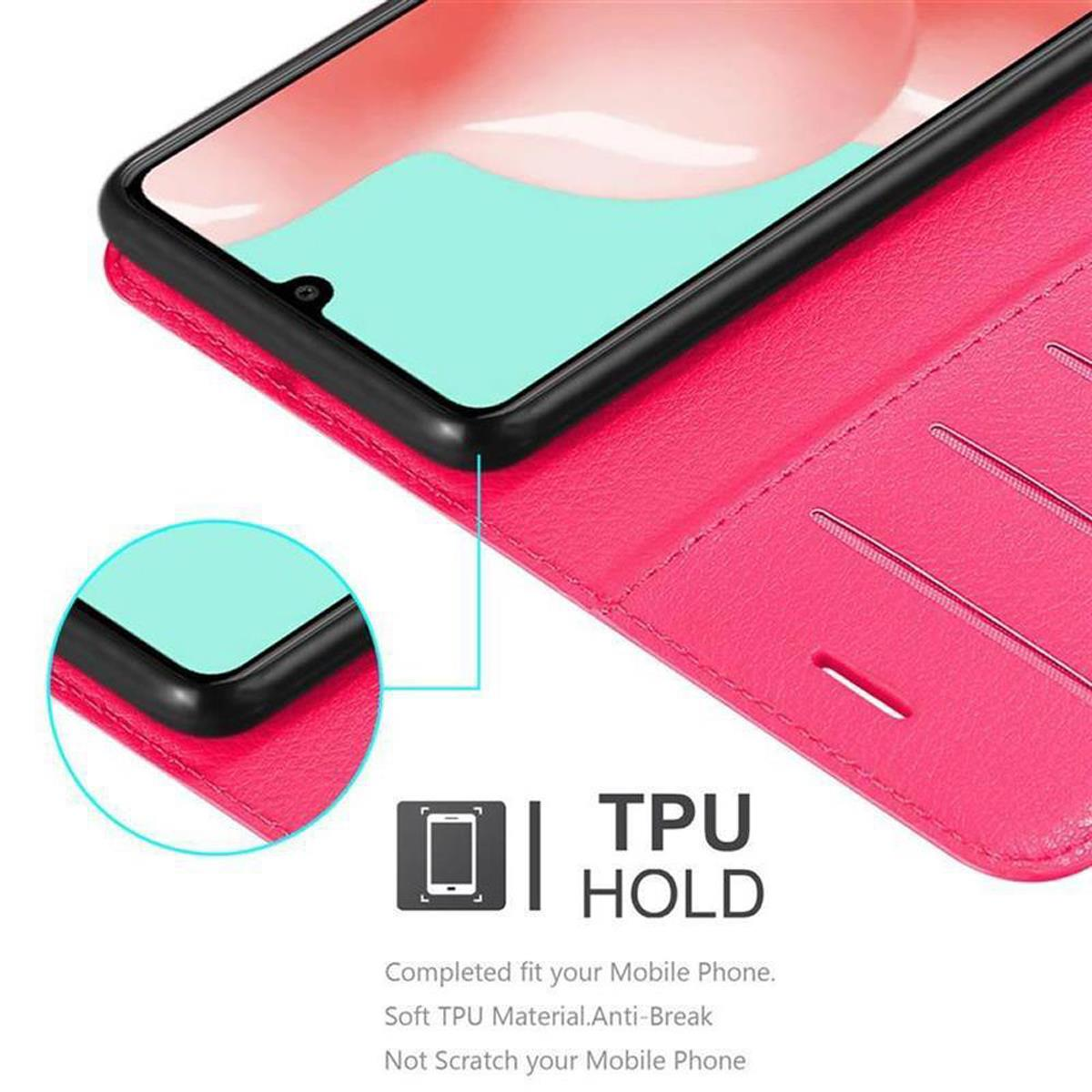 Ein rosa Handyhülle offen mit einem Telefon darin. Das Telefon befindet sich in einem schwarzen Halter. Texte über die Hülle sind sichtbar.