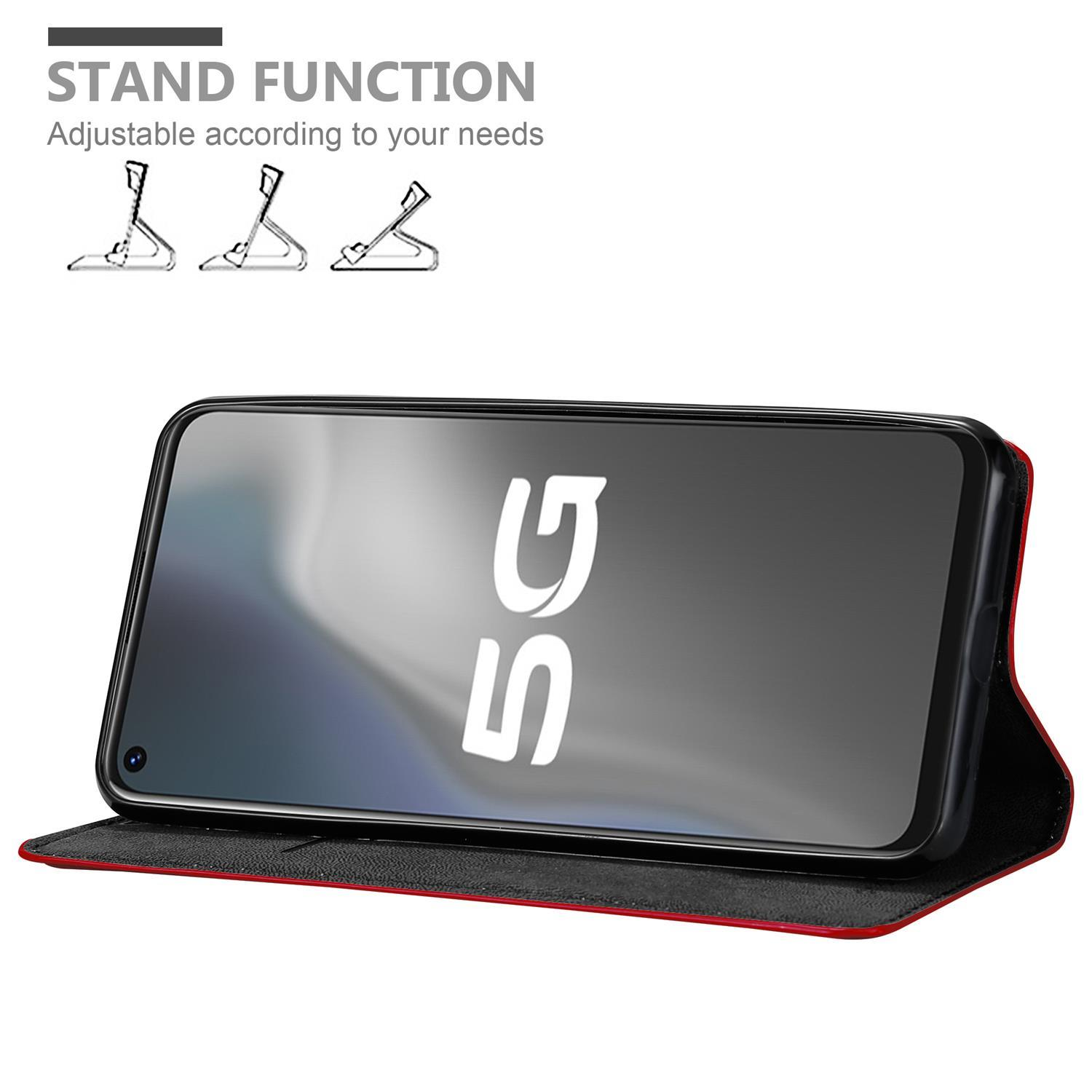 Rote Handyhülle, die ein Telefon unterstützt. Das Telefon zeigt ein 5G-Symbol. Weißer Hintergrund.