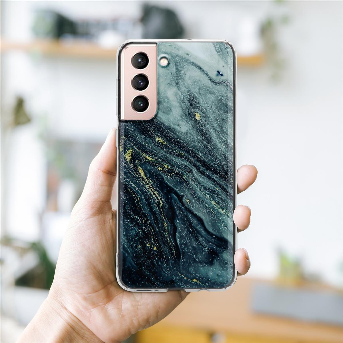 Mano che tiene un telefono con una custodia effetto marmo. La custodia ha un bordo dorato e tre fotocamere.