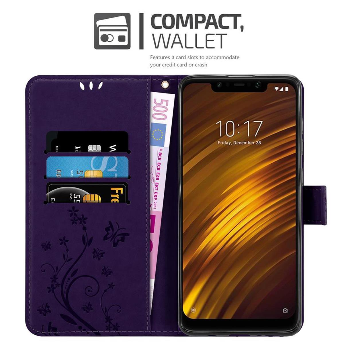 Una custodia viola, aperta per rivelare un telefono, carte e denaro. Ha un design floreale.