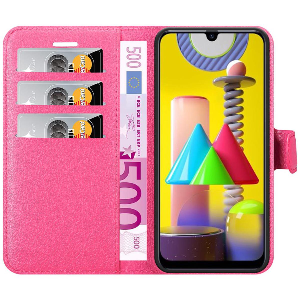 Custodia rosa per telefono aperta, che mostra carte di credito, denaro e un telefono con arte astratta colorata.