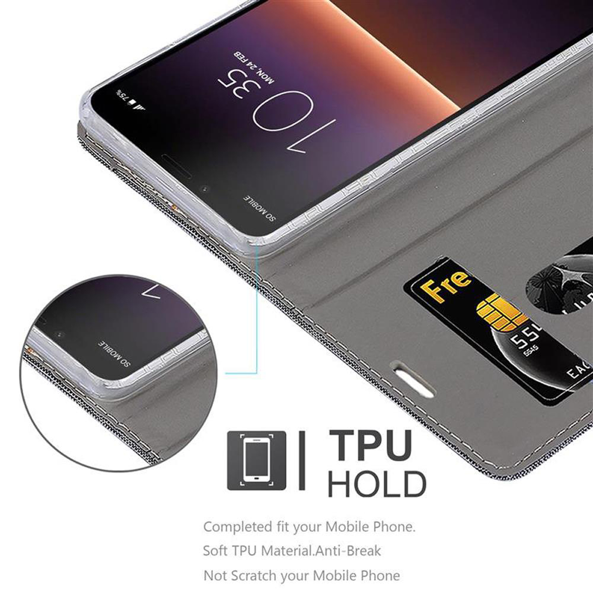 Telefono in custodia grigia con carta. La custodia è aperta. Lo schermo mostra l'ora.