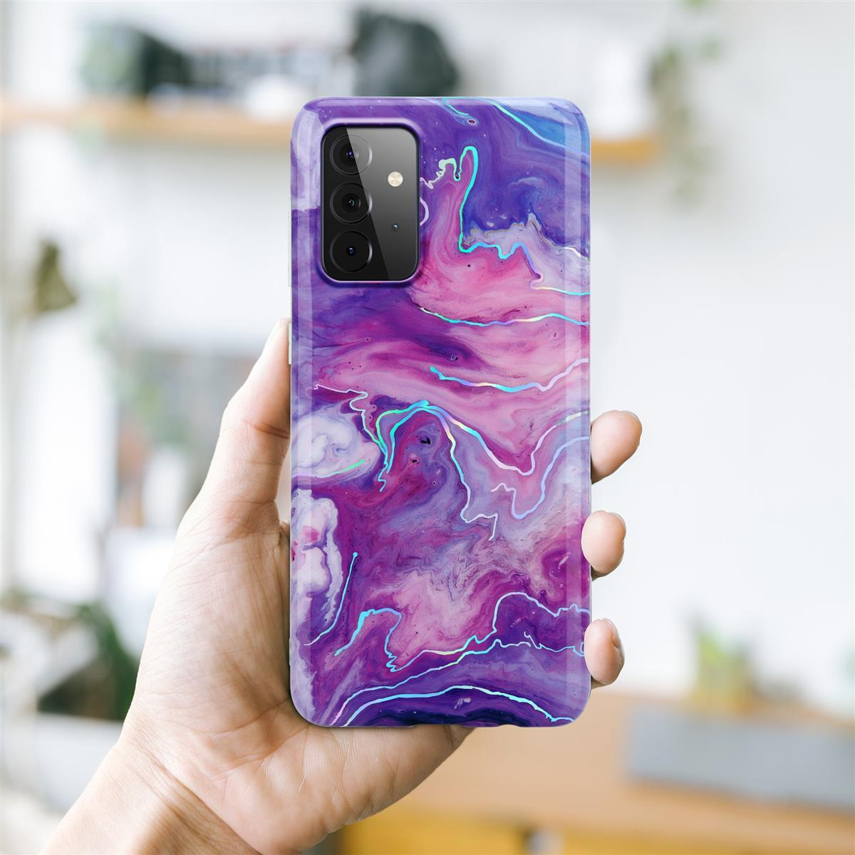 Una mano che tiene un telefono. Il telefono ha una custodia con un design a marmo viola e rosa.