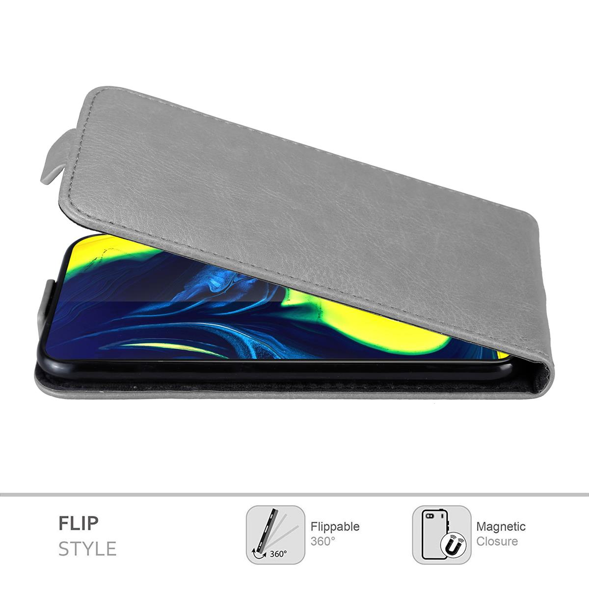 Eine graue Handyhülle mit einem Telefon darin. Die Hülle ist geöffnet. Der Text lautet "Flip Style".