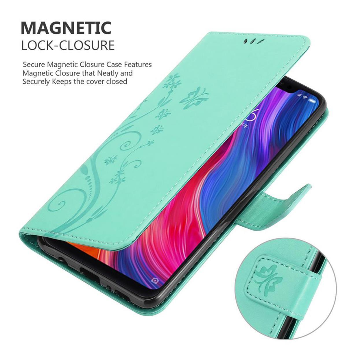 Custodia per telefono turchese con design floreale e chiusura magnetica, che tiene un telefono.