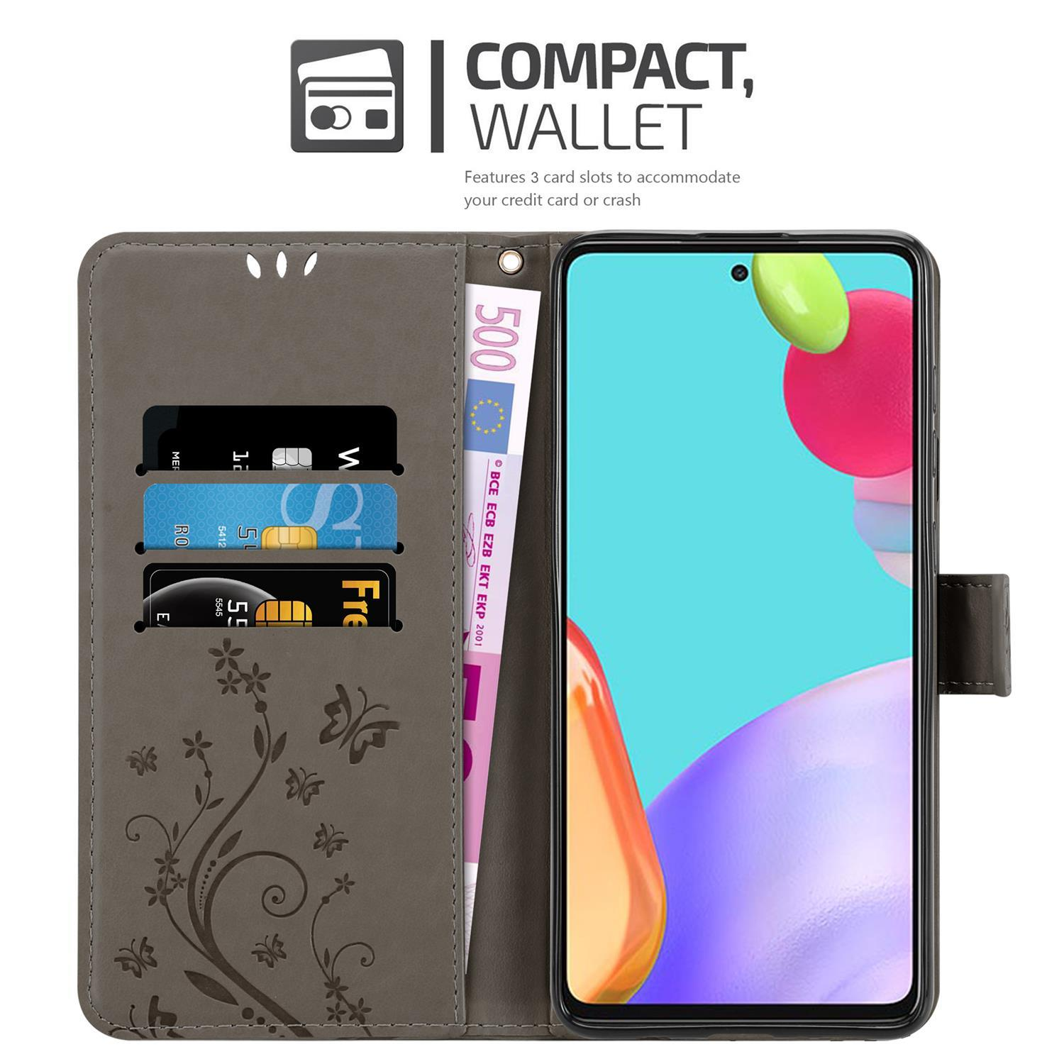 Eine graue Handyhülle öffnet sich und zeigt ein Telefon, Karten und Bargeld. Das Gehäuse hat ein Blumendesign.