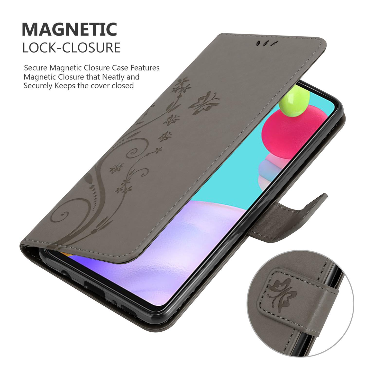 Eine graue Handyhülle mit floralem Design. Sie ist teilweise geöffnet und zeigt das Telefon im Inneren. Sie hat einen Verschluss.