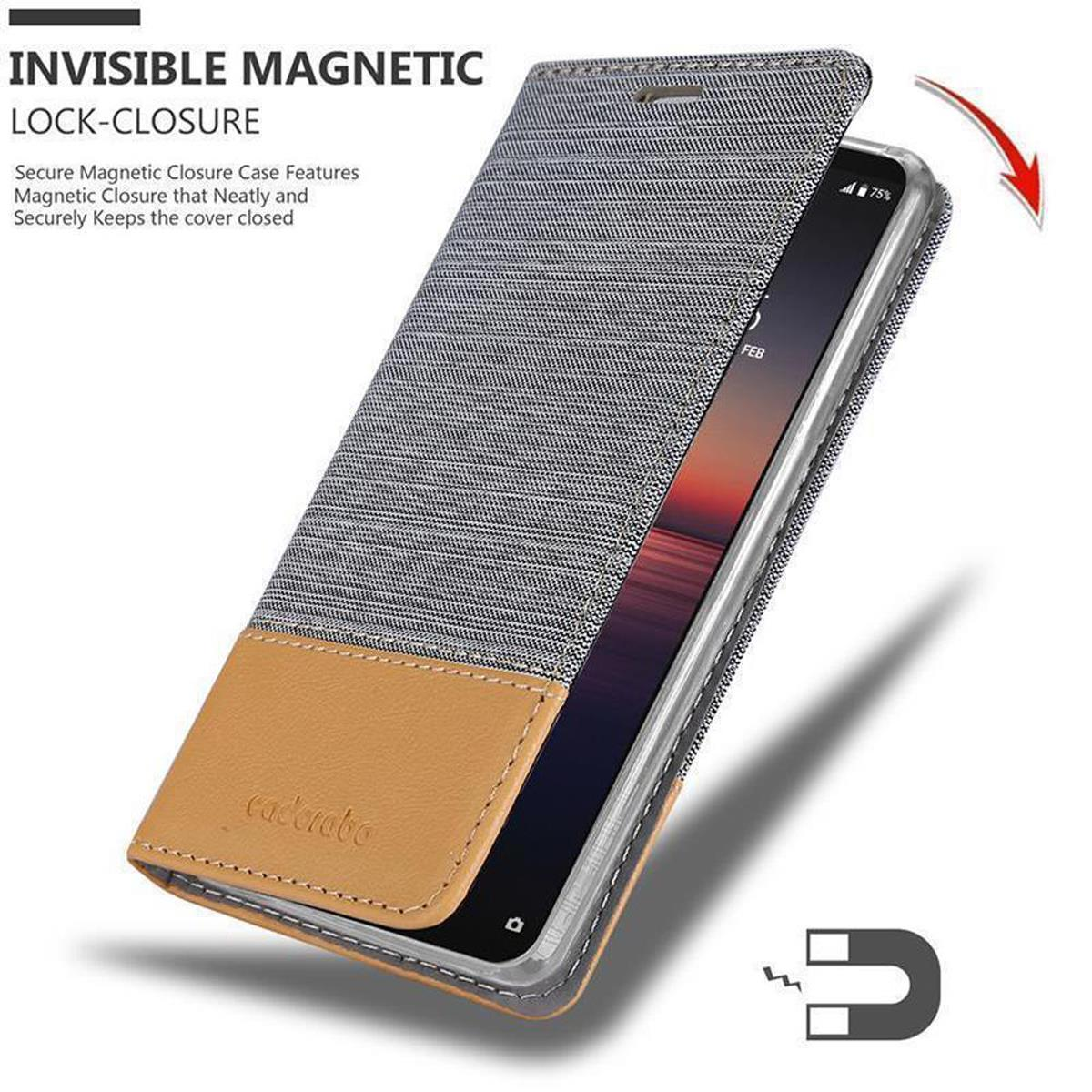 Custodia del telefono aperta. Parte superiore in tessuto grigio, parte inferiore marrone. Schermo del telefono visibile. Chiusura magnetica.