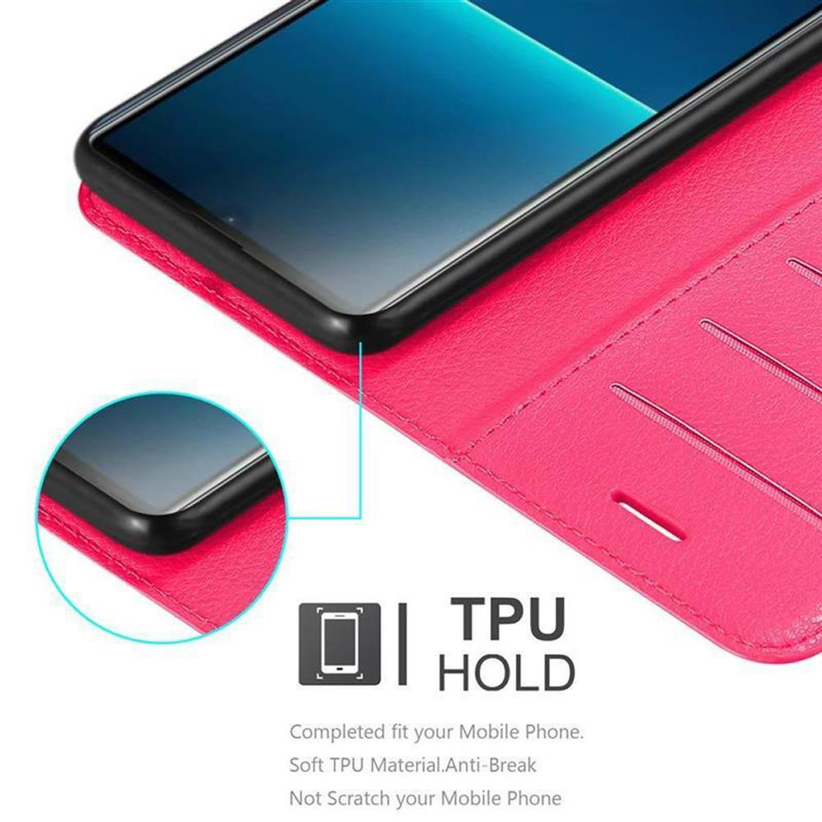 Telefono in custodia rosa. Il testo dice 'TPU HOLD'.
