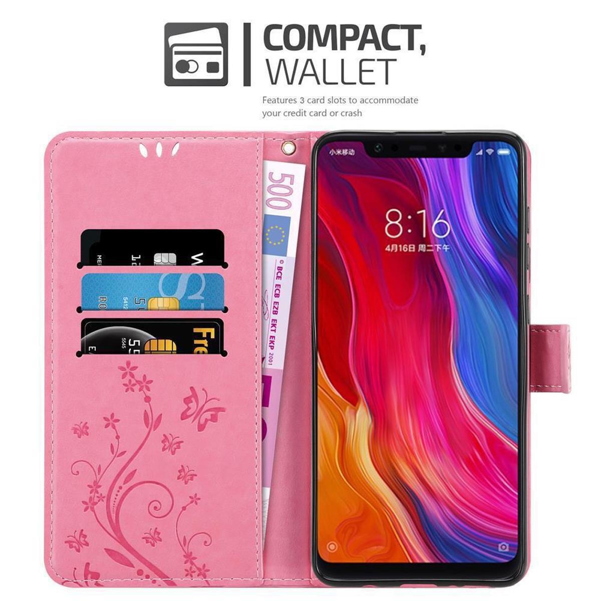Custodia rosa, telefono all'interno, con fessure per carte e denaro. Testo: Compact Wallet.