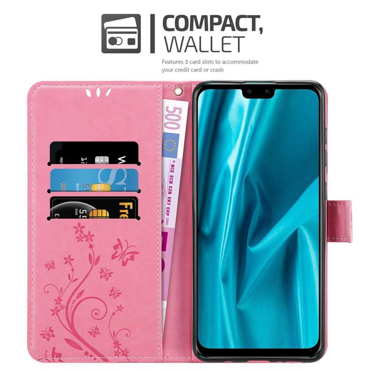 Cartera de teléfono rosa abierta con tarjetas, un billete de 500 euros y un teléfono. Fondo blanco.
