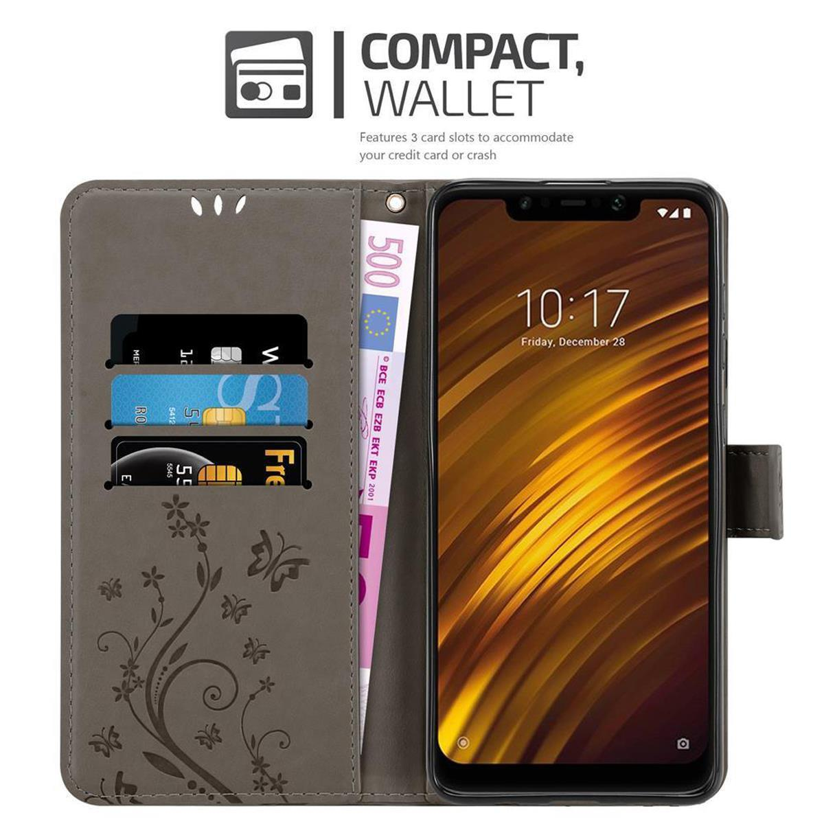 Telefono in una custodia a portafoglio grigia aperta. Carte e banconota da 500 euro visibili. Schermo acceso.
