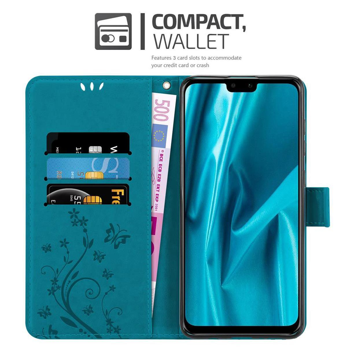 Funda de teléfono verde azulado con ranuras para tarjetas y dinero. Teléfono dentro de la funda mostrando la hora y la fecha.