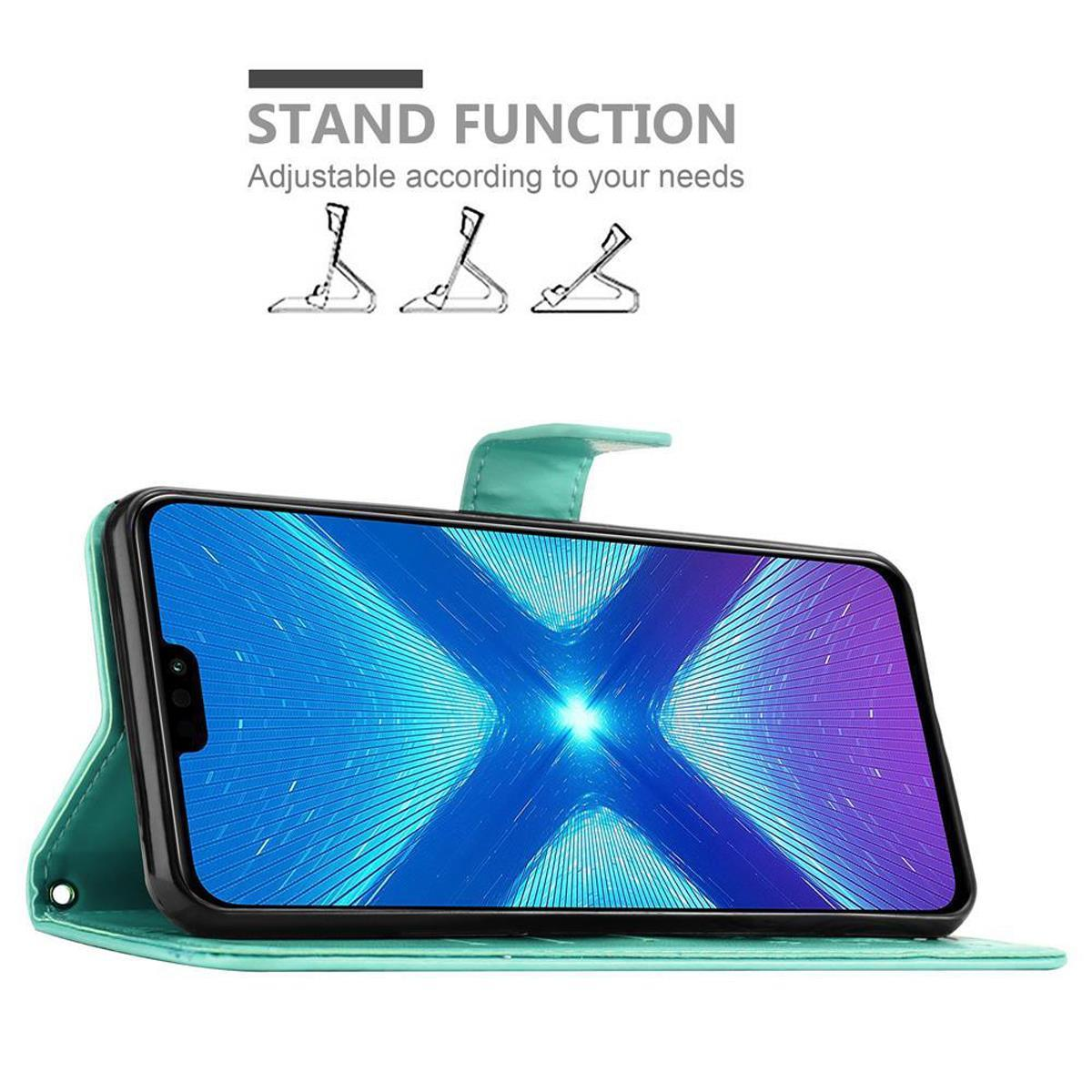 Telefono in custodia aperta, che mostra lo schermo. Testo: Funzione stand, regolabile. Telefono appoggiato.