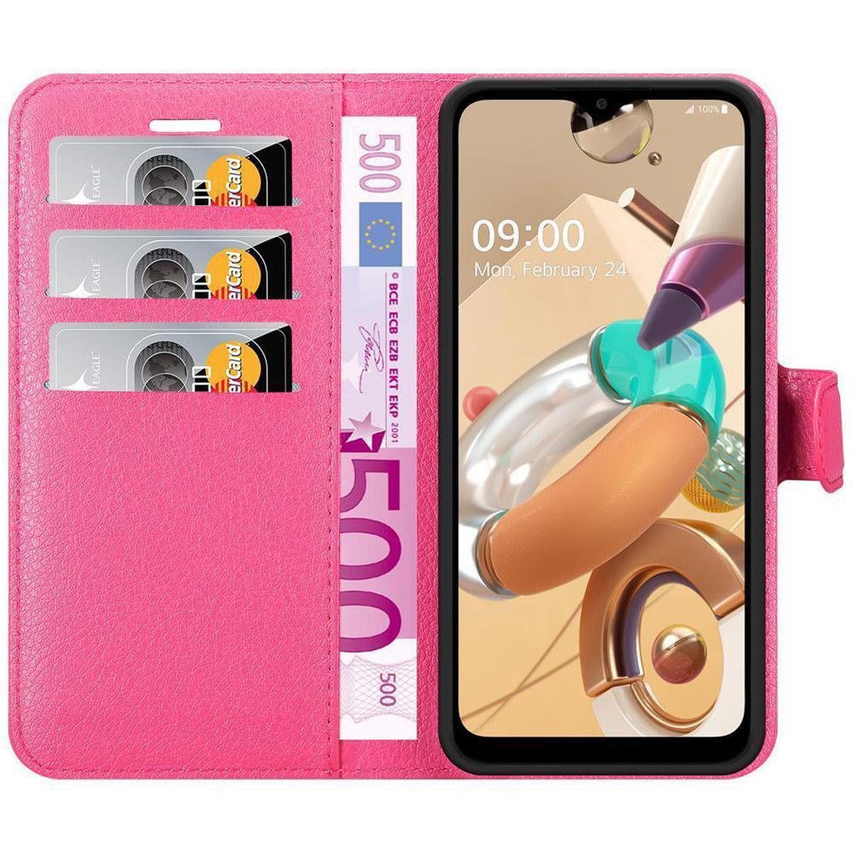 Una custodia per telefono rosa a portafoglio con un telefono all'interno. Il telefono mostra l'ora e la custodia contiene denaro e carte.
