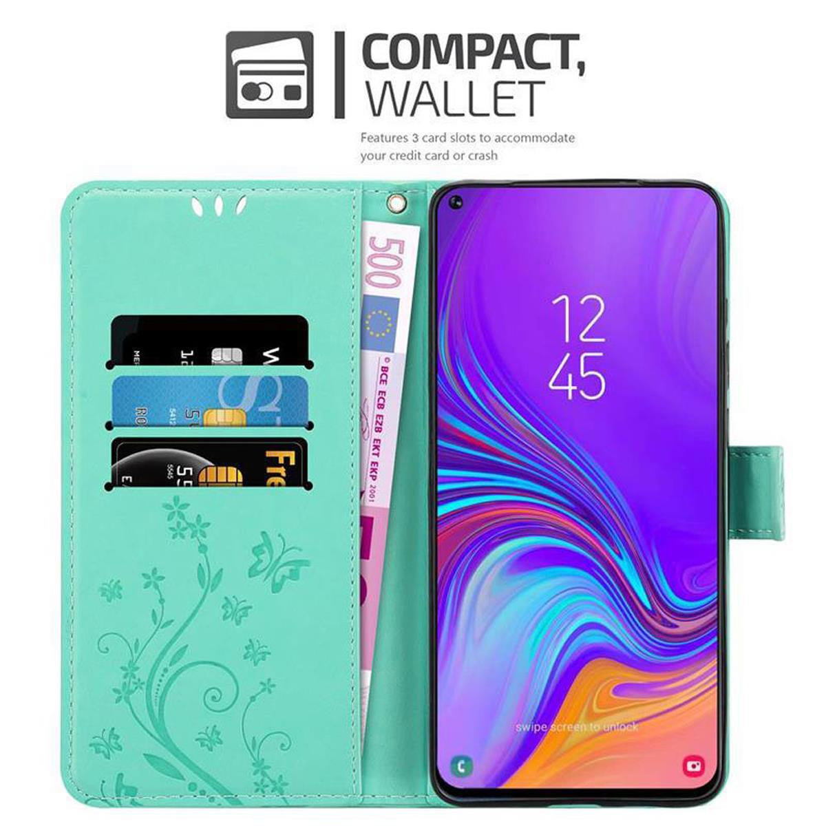 Una custodia a portafoglio turchese aperta che mostra carte e denaro. Il telefono mostra l'ora. Il testo è 'COMPACT, WALLET'.