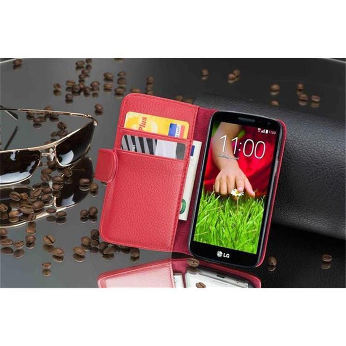 Custodia a portafoglio rossa aperta, con telefono, carte e denaro. Occhiali da sole e chicchi di caffè sullo sfondo.