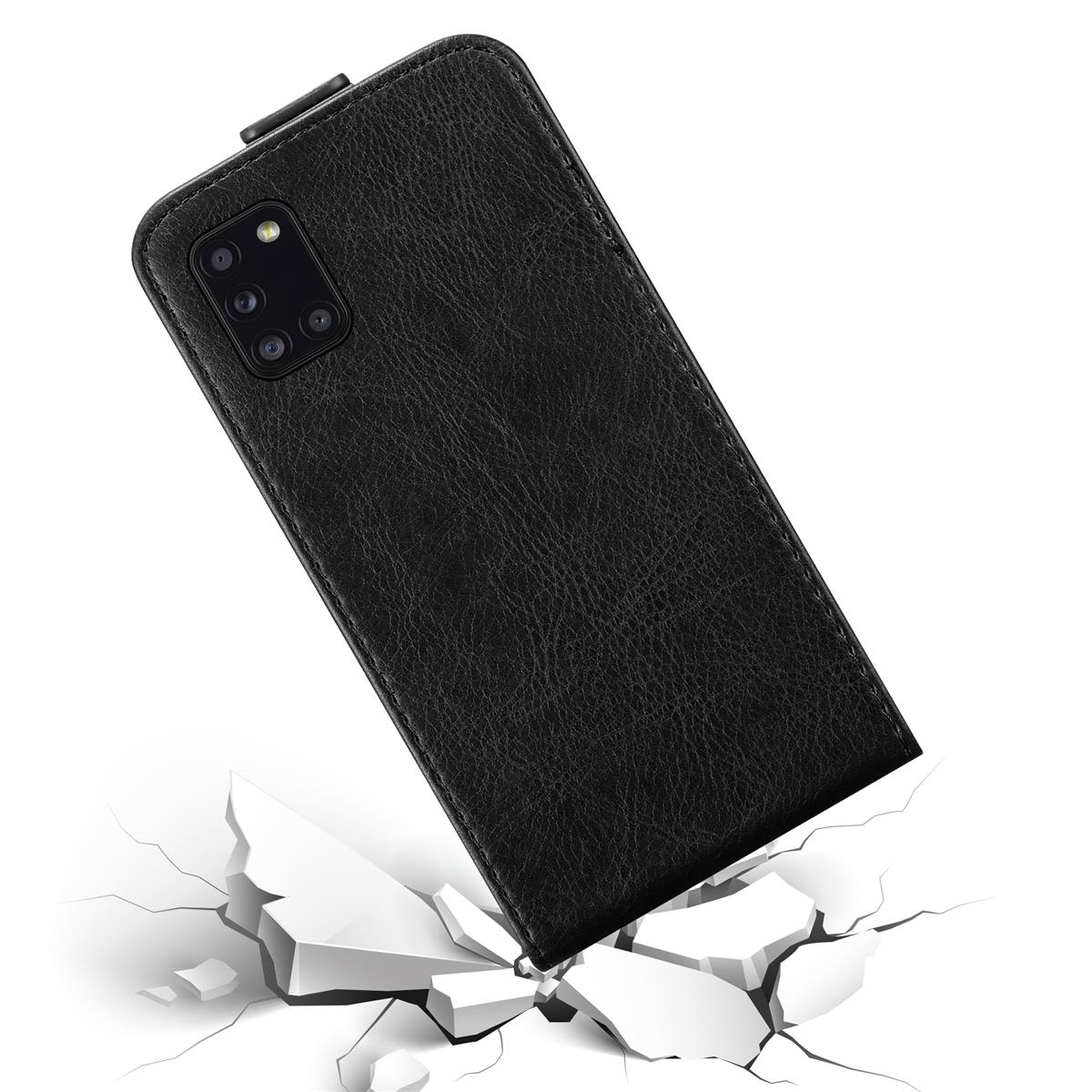 Schwarze Handyhülle. Ein Telefon ist darin. Rissiger Boden im Hintergrund.