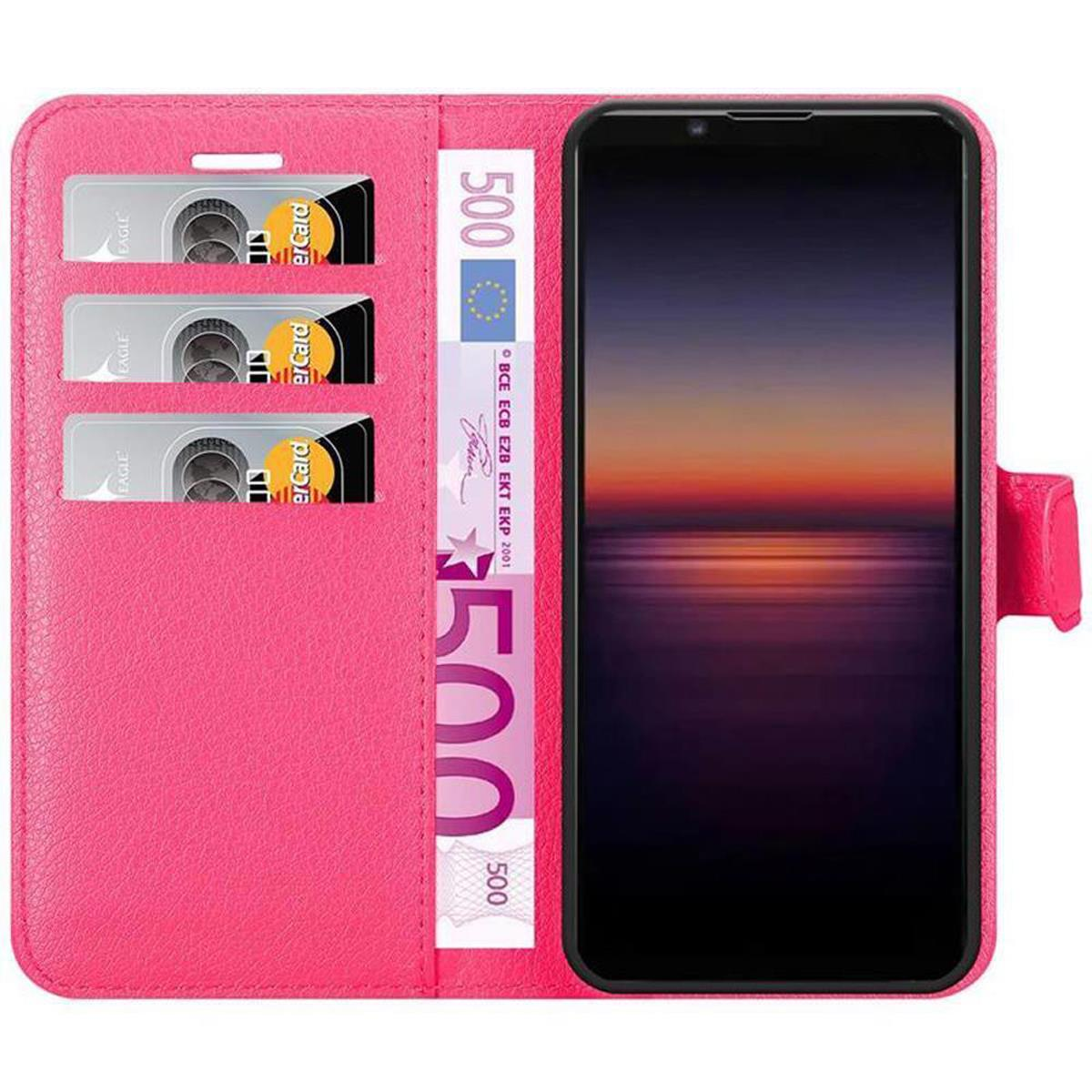 Custodia rosa per telefono con telefono, carte e denaro. Schermo mostra tramonto. Carte e denaro visibili.