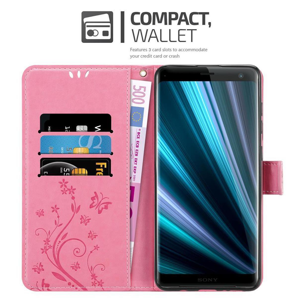 Custodia per telefono rosa con telefono, carte di credito e denaro. Con un design floreale.