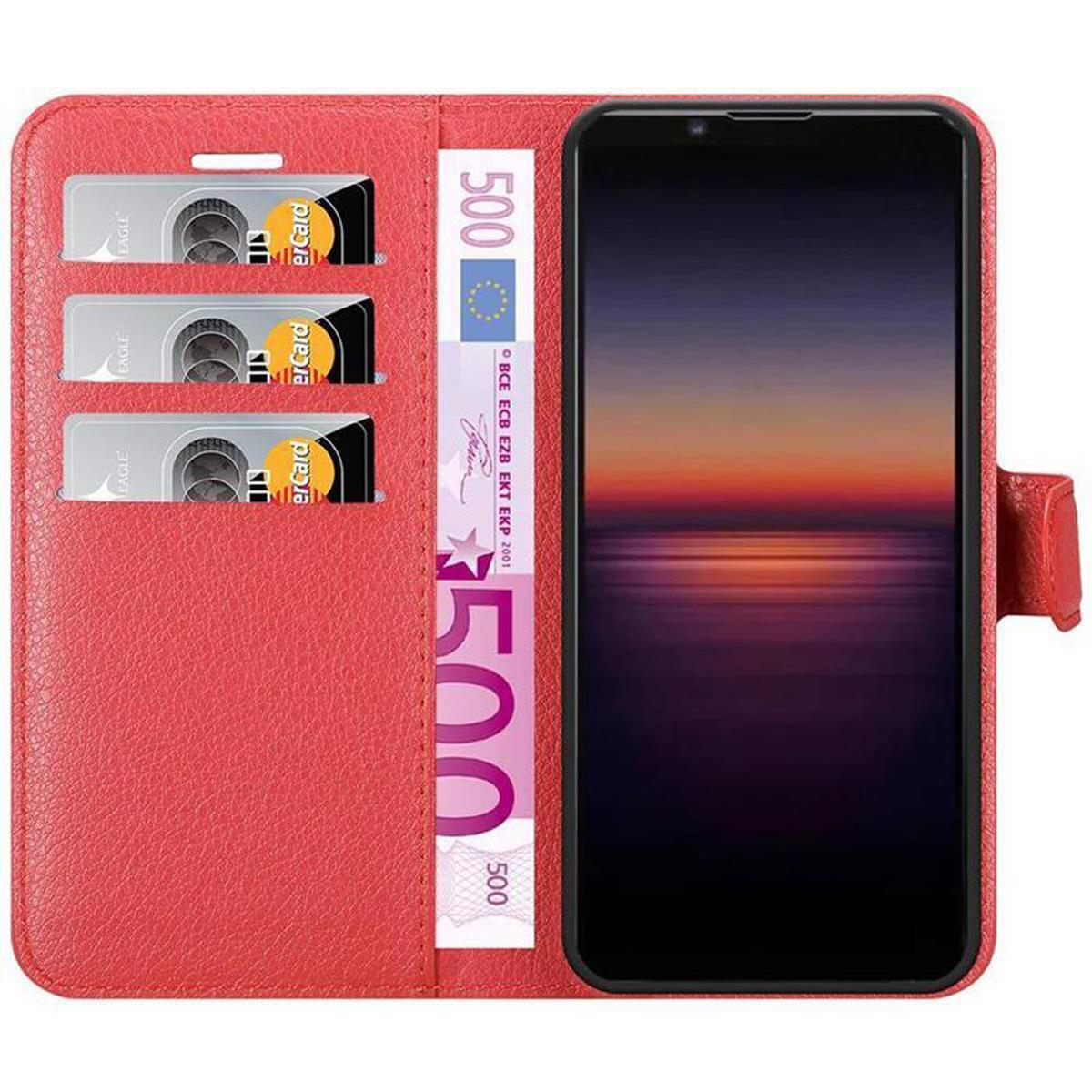 Una custodia rossa per telefono aperta con un telefono e carte all'interno. Sono visibili anche banconote.