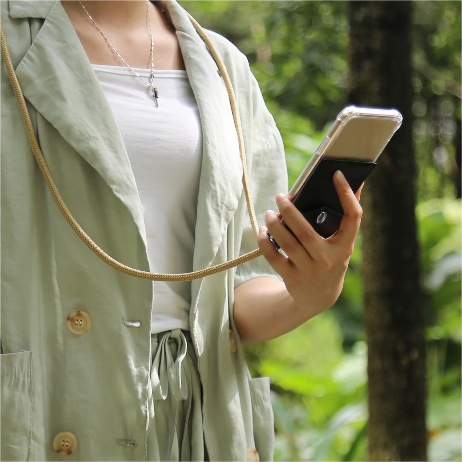 Eine Frau hält ein Telefon mit einem Umhängeband. Das Telefon ist in einer Hülle mit Halter.