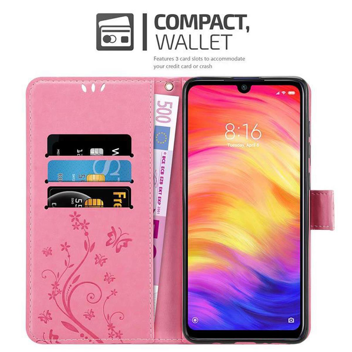 Custodia a portafoglio rosa aperta con tre slot per carte, contanti. Il telefono mostra uno schermo viola.