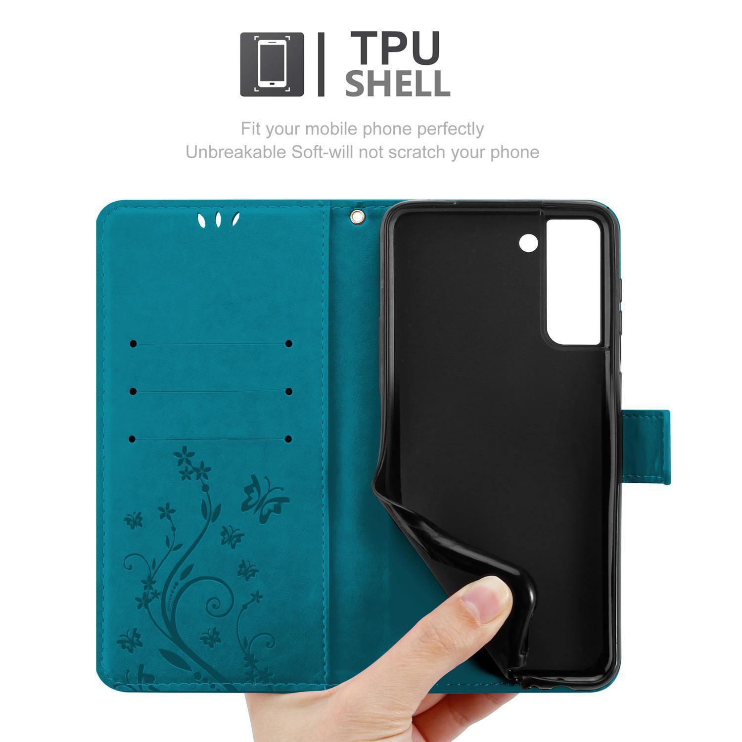 Una custodia a portafoglio per telefono verde acqua aperta, con una mano che tiene il telefono lontano. Design floreale visibile.