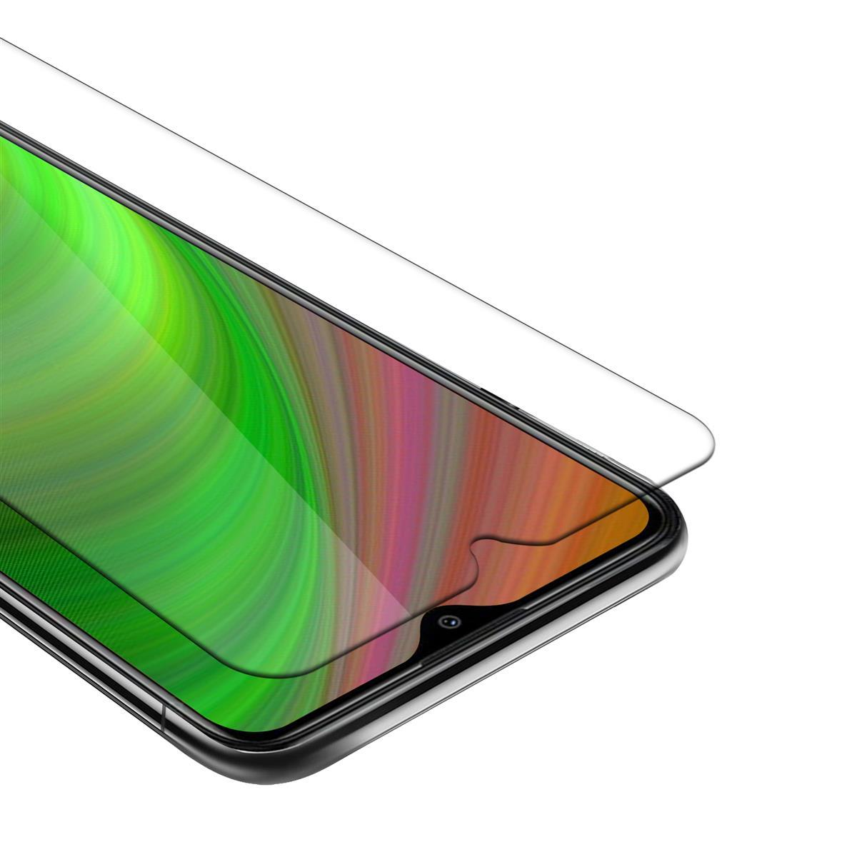 Schermo smartphone con protezione applicata. Sfondo verde e rosa visibile.