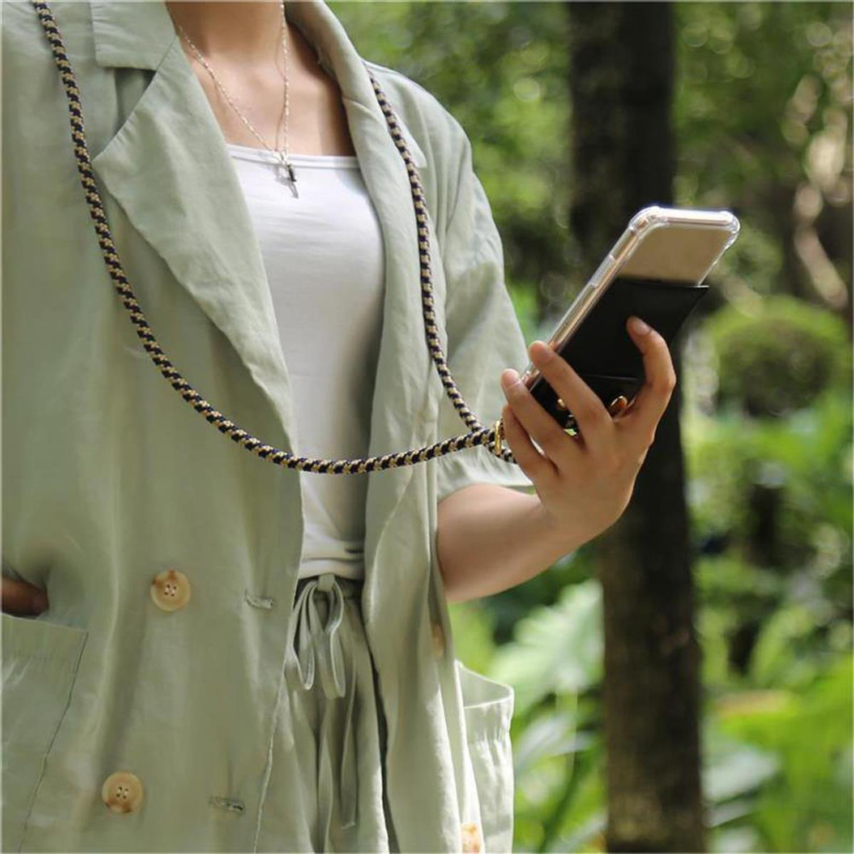 Donna tiene telefono con cordino. Cordino beige. Sfondo natura.