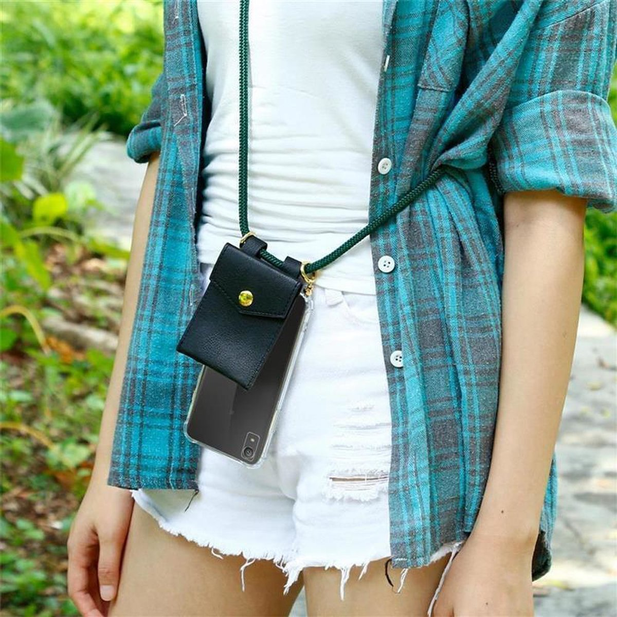 Eine Person trägt ein blau kariertes Hemd und weiße Shorts. Sie halten ein Telefon in einer schwarzen Tasche.