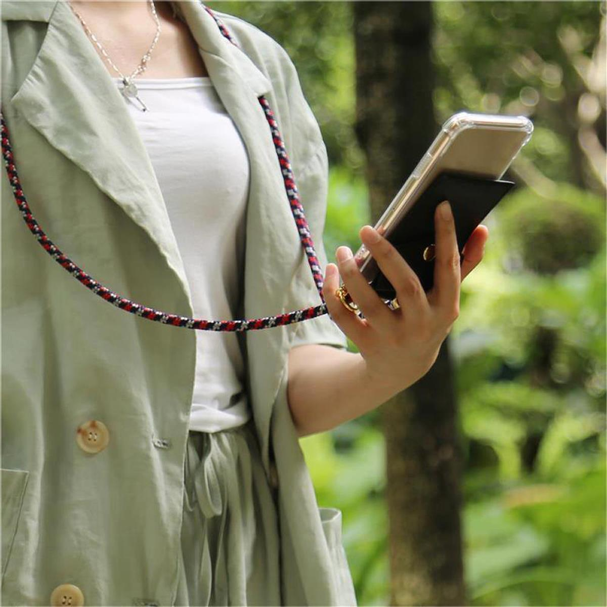 Persona che tiene un telefono in una custodia, indossa una giacca verde con un cinturino rosso, all'aperto.