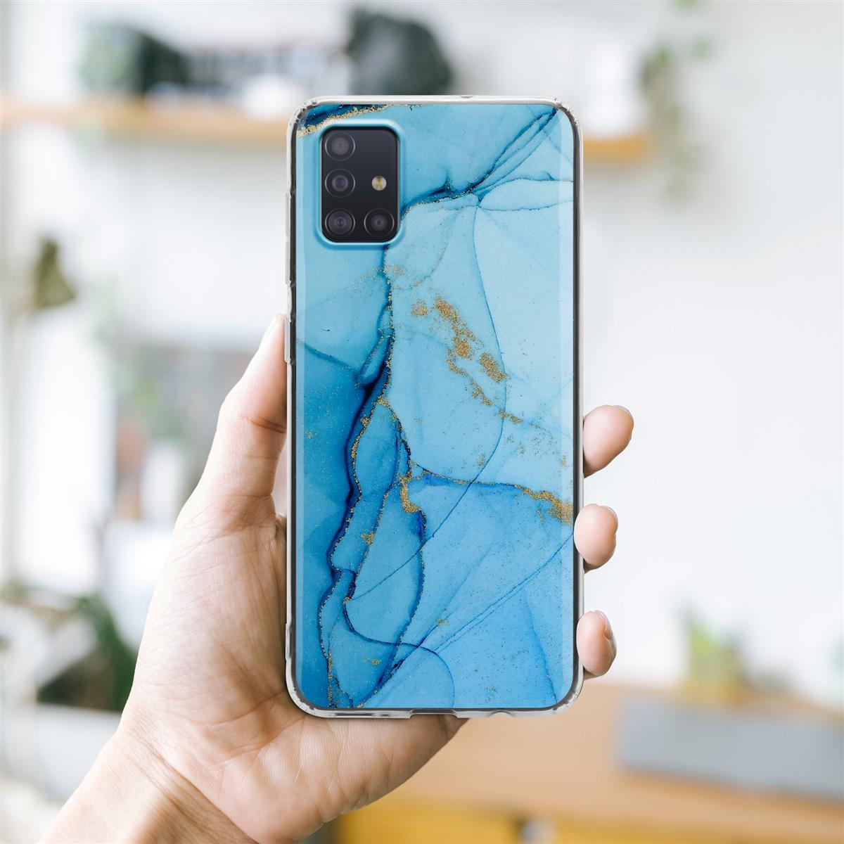 Mano che tiene un telefono con una custodia blu effetto marmo. Macchie dorate nel design.