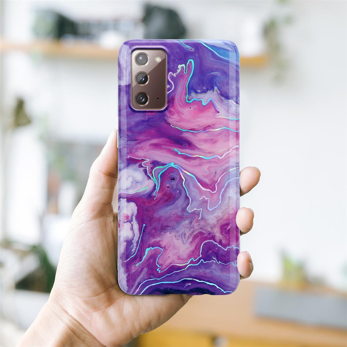 Custodia per telefono con design colorato. Vortici viola e rosa. Mano che tiene il telefono.