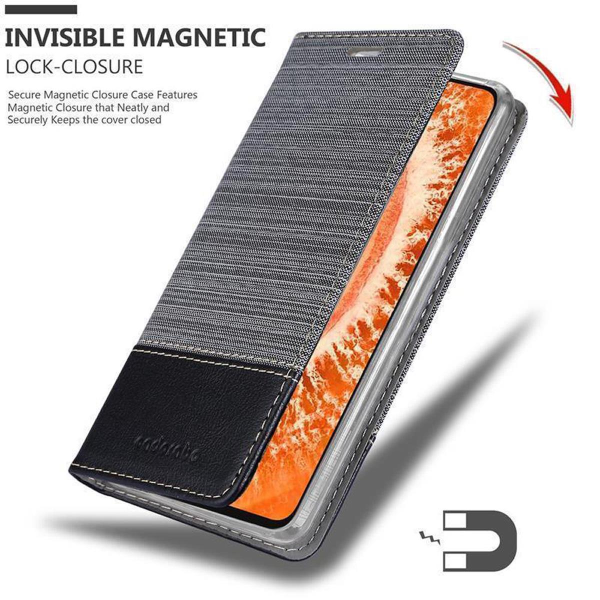 Custodia per telefono nera e grigia aperta per rivelare il telefono. Viene mostrato un magnete. Sfondo bianco.