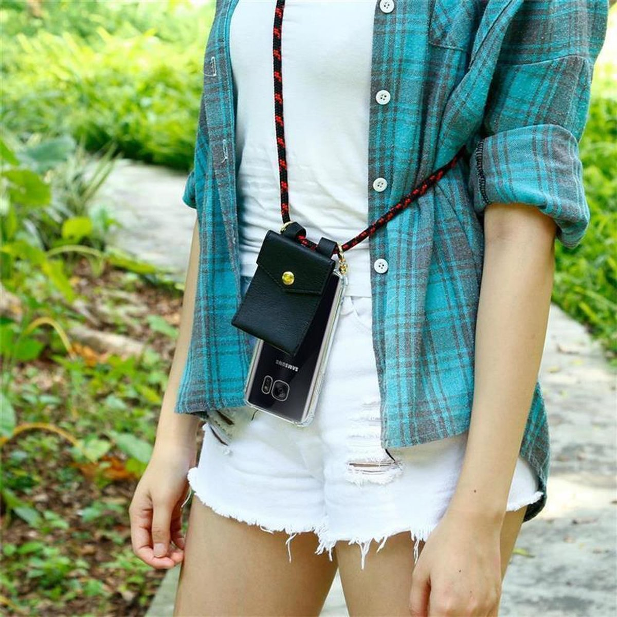 Donna con collana con custodia per telefono, all'aperto con sfondo verde.