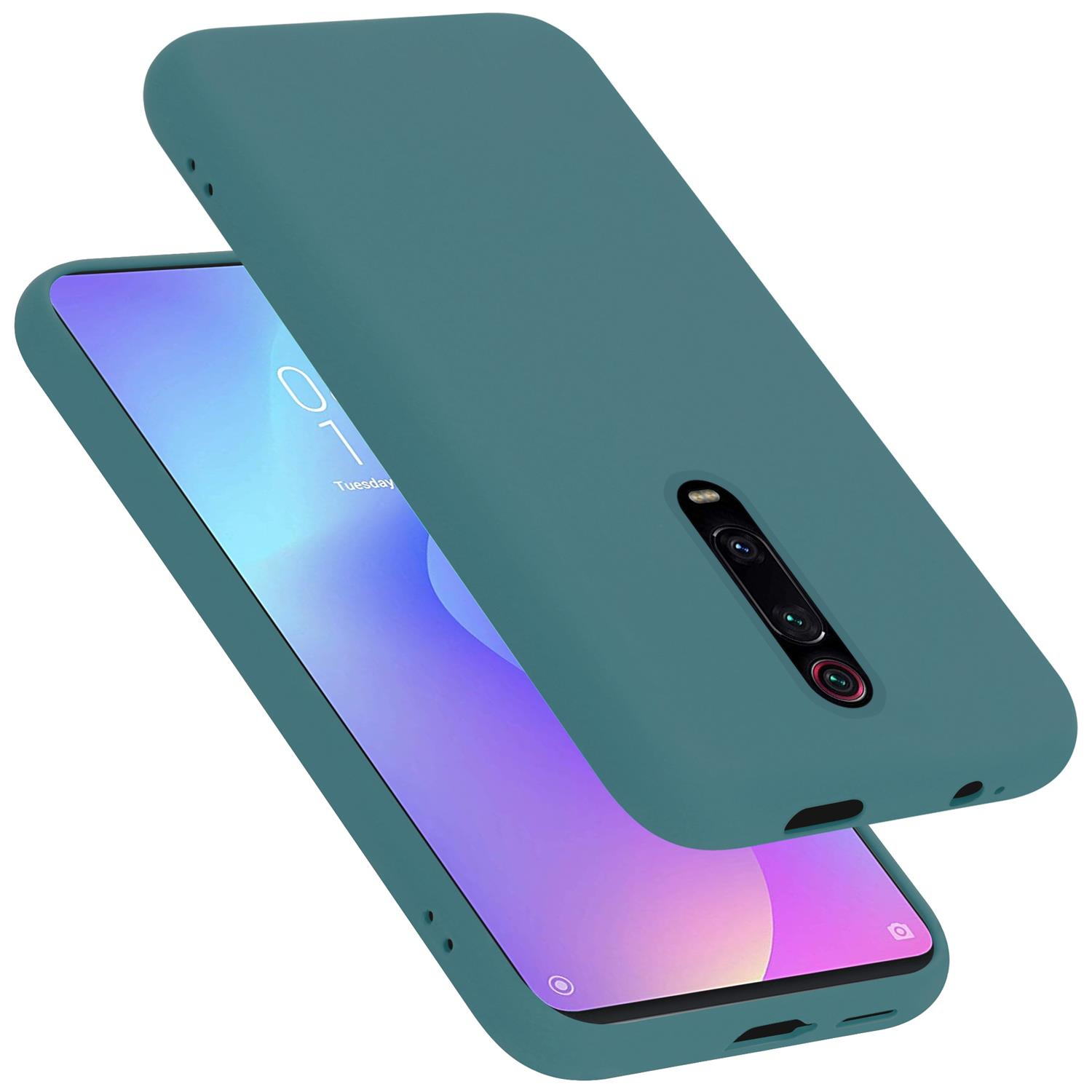 Una custodia per telefono verde acqua con un telefono all'interno. L'obiettivo della fotocamera è visibile. La data è sullo schermo.