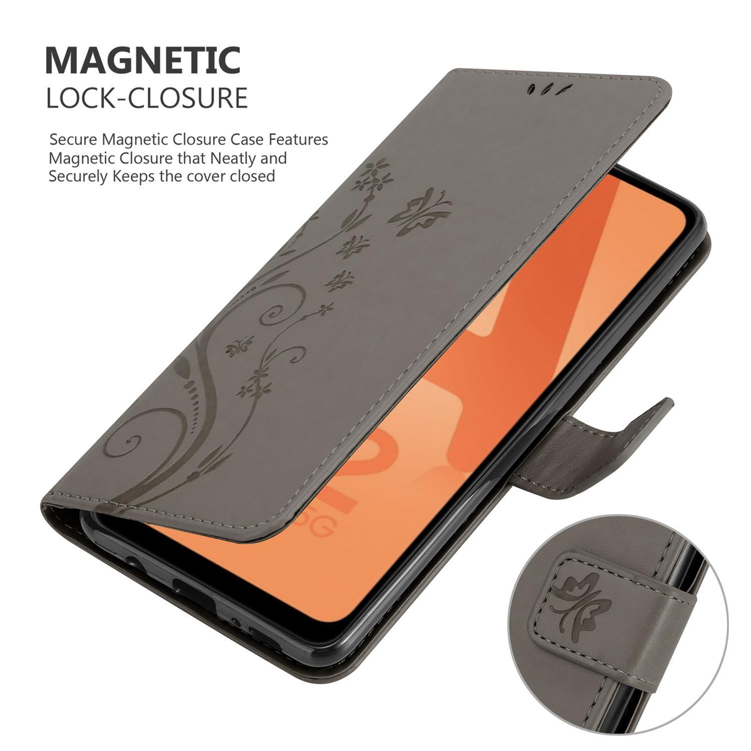 Una custodia per telefono grigia con design floreale, aperta, che rivela il telefono con il suo schermo visibile e un primo piano di una chiusura.