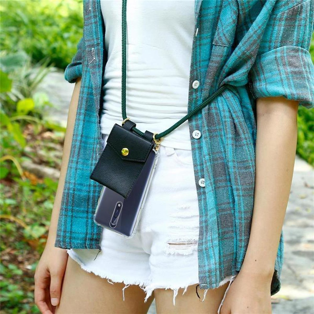 Frau mit weißem Tanktop, Shorts und blauem Karoshemd, mit einer Handytasche.
