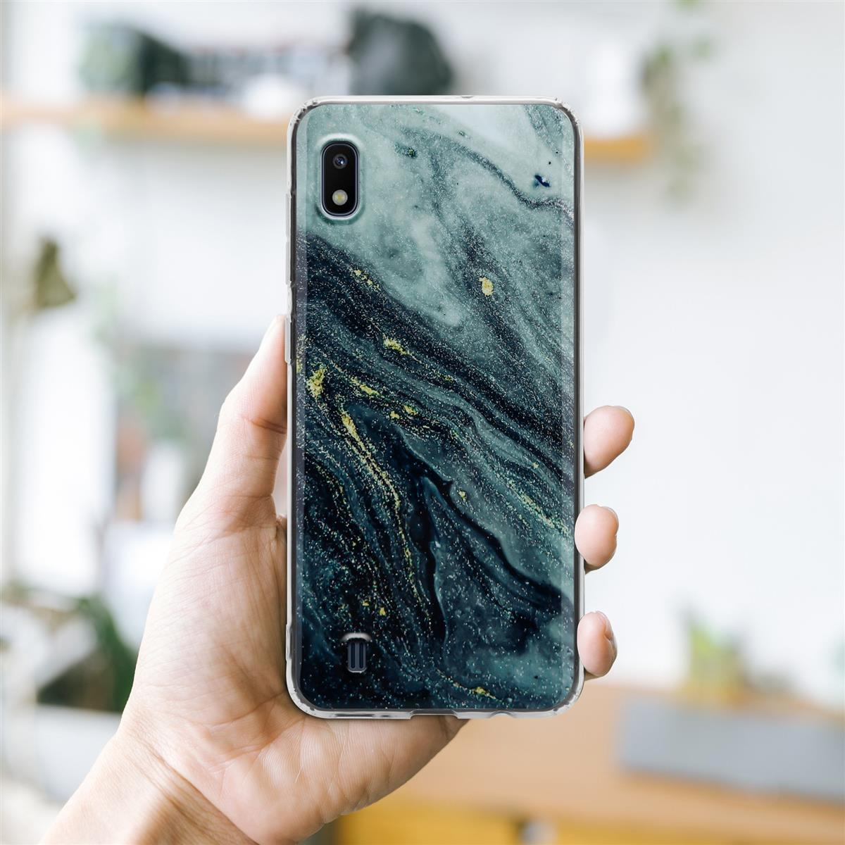 Mano che tiene un telefono in una custodia con un design marmorizzato. Sfondo luminoso.