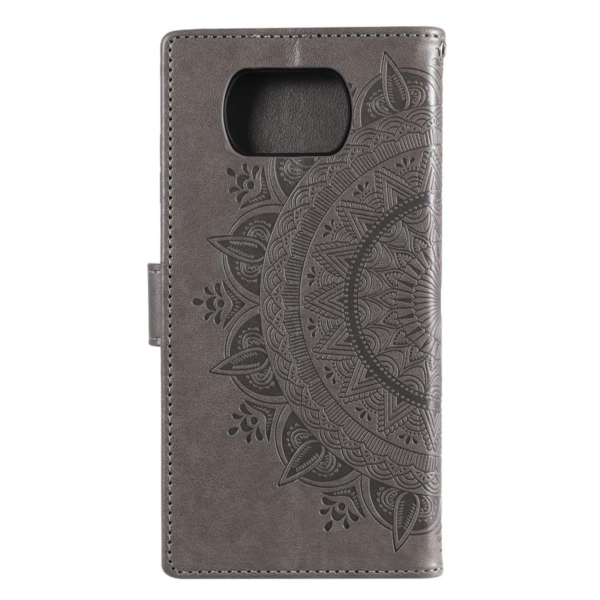 Graue Handyhülle mit Mandala-Design, geschlossen. Mit aufwändigem kreisförmigem Muster und Magnetverschluss.