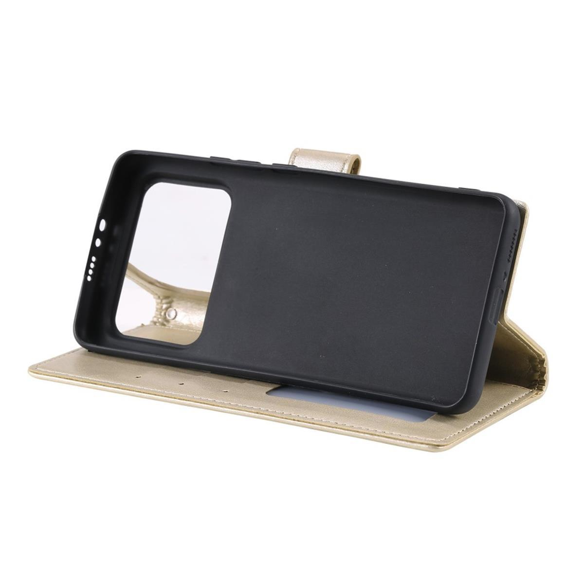 Geöffnete goldene Handyhülle mit einem Telefon darin. Der Innenteil ist schwarz.