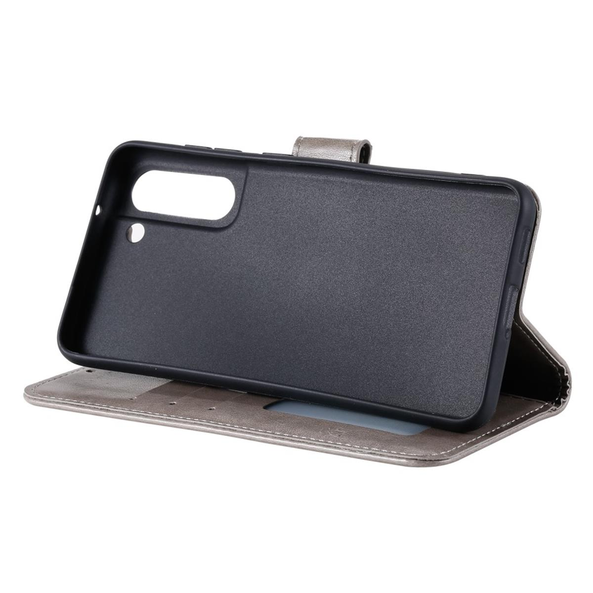 Ein schwarzes Telefon in einer grauen und silbernen Brieftasche, offen und flach liegend.