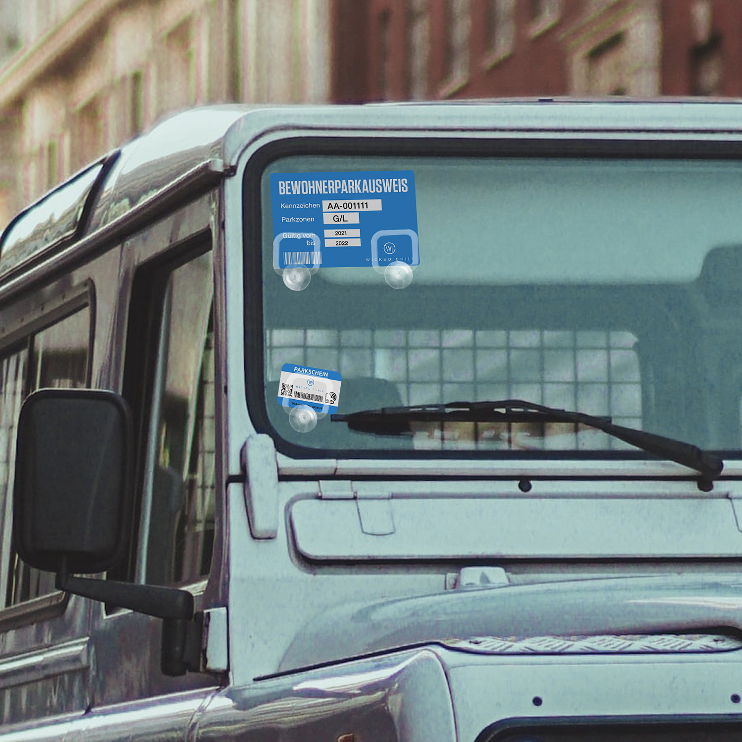 Ein Autofenster mit Parkausweis. Das Auto ist weiß. Straße im Hintergrund.