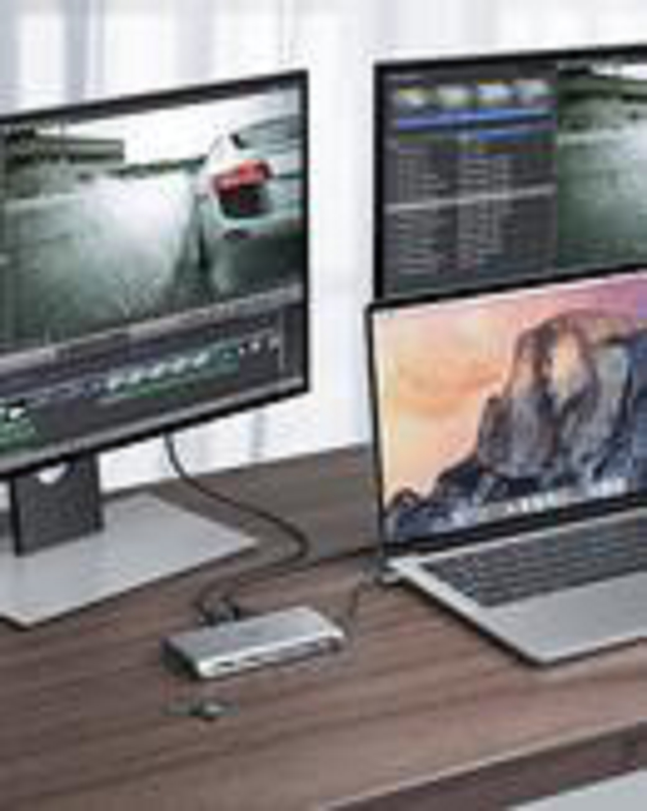 Laptop und zwei Monitore mit Hub auf einem Holztisch.