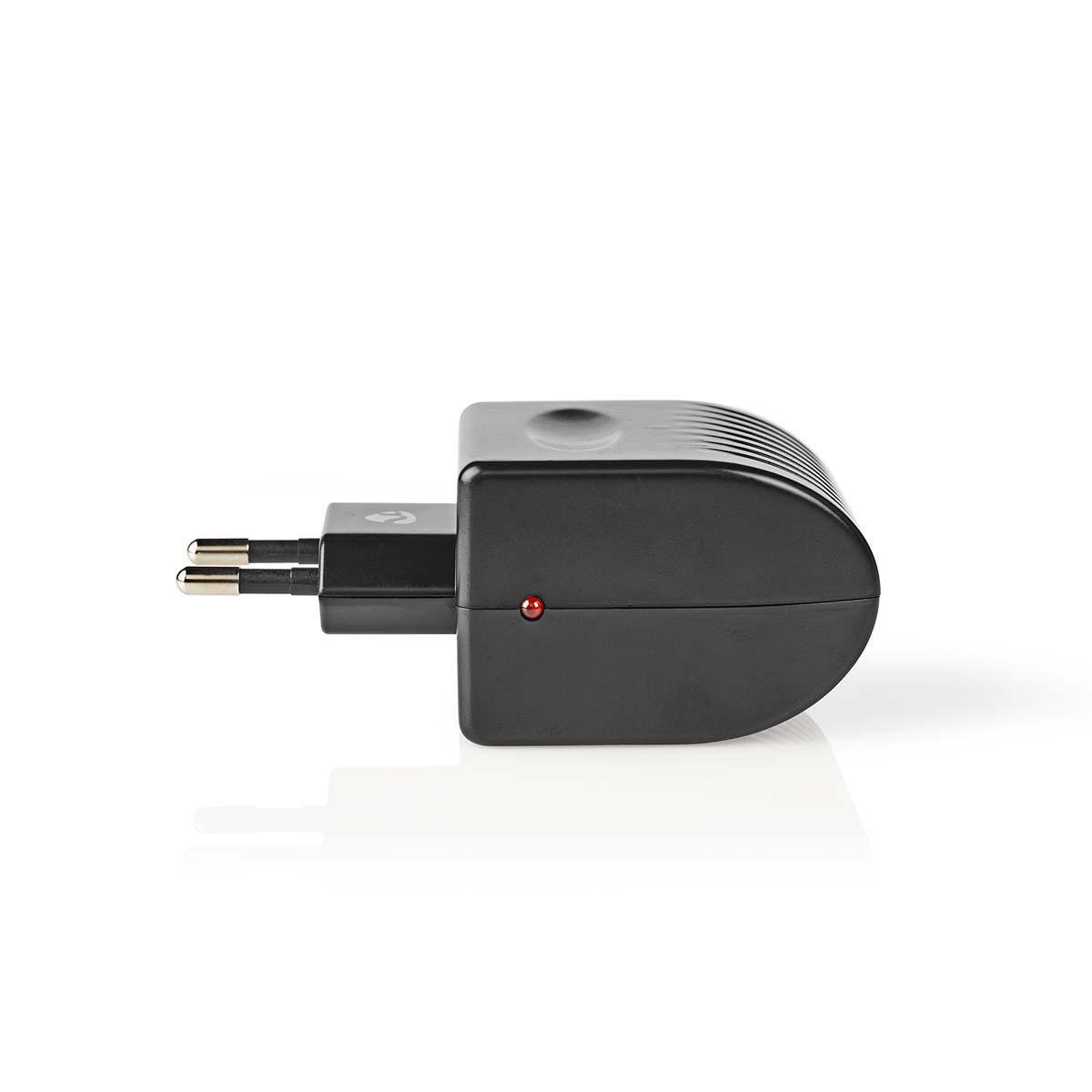 Ein schwarzer Adapter mit Stiften und roter Kontrollleuchte auf weißem Hintergrund.