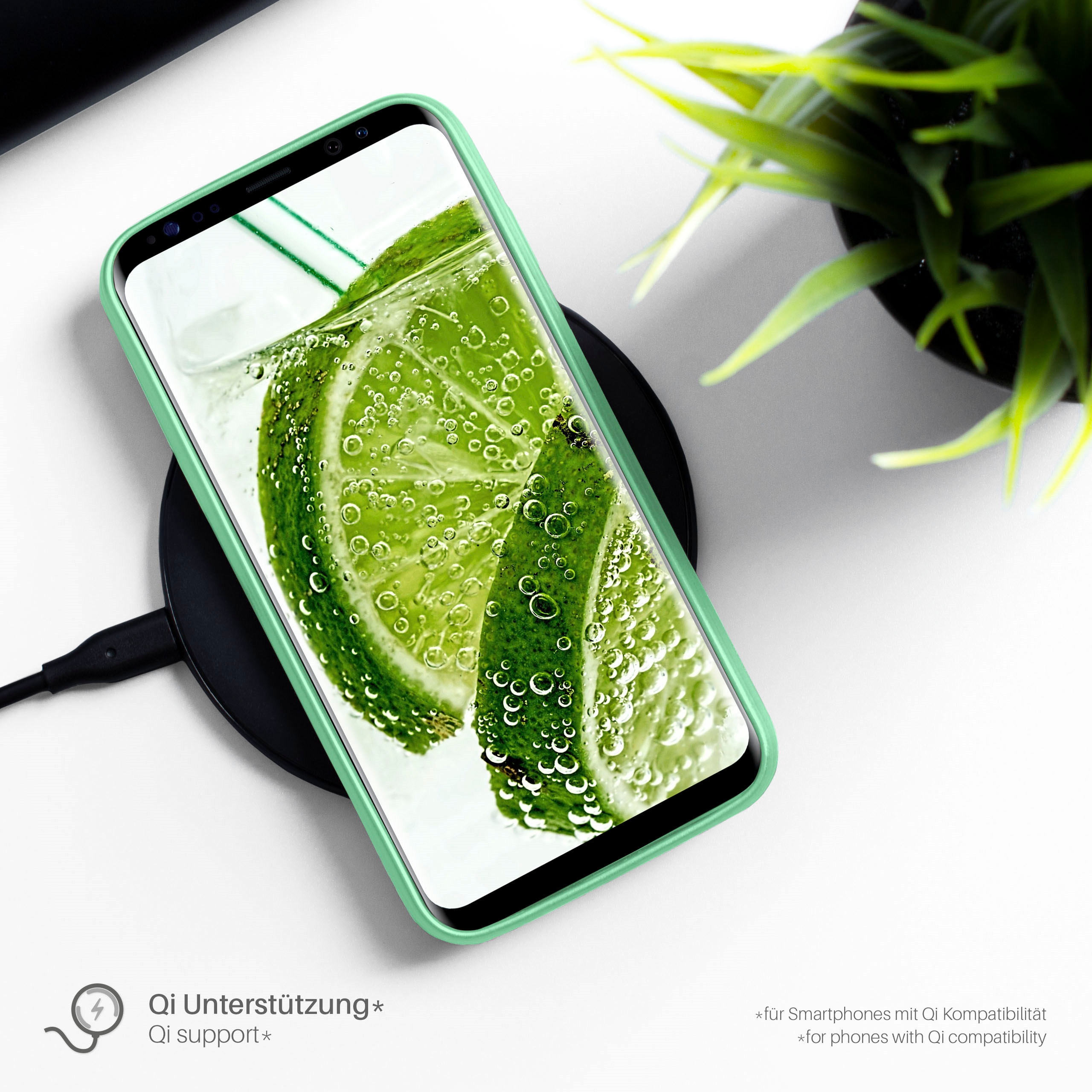 Smartphone in einer Hülle auf einem kabellosen Ladegerät. Der Bildschirm zeigt eine Limette und Wasser.